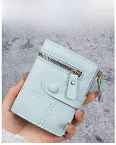 Detail view of light blue lychee pattern faux leather wallet with snap closure and zippers