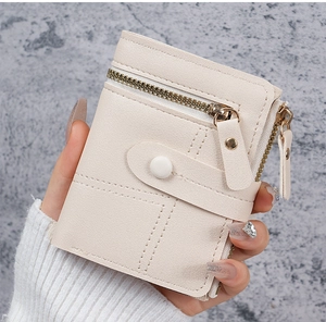 Detail of cream PU leather wallet with cross-grain texture and gold-tone zippers