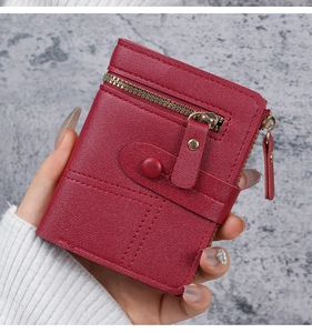 Detailed view of wine red pebbled leather card holder wallet with gold zipper and snap