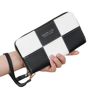 Long checkerboard wallet in black and white pebbled leather with a gold zipper and wristlet