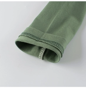 Detail of green cotton knit sleeve showing professional overlock stitching and fabric texture