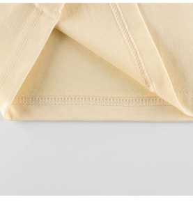 Detail of double-needle stitching and hem on the light yellow cotton knitted t-shirt