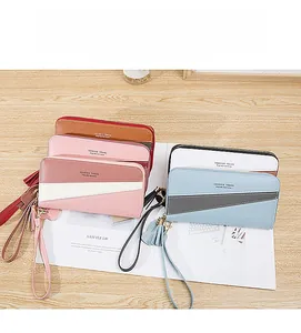 Detail of color-block patchwork long wallets with zipper and stylish tassel pendants