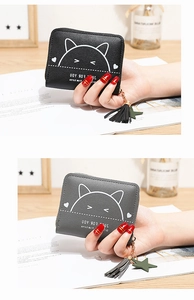 Close-up of compact PU leather zip wallets featuring cute cat prints and tassel charms