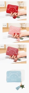 Close-up of cat print wallets with tassel zipper pulls in red, pink, and blue colors