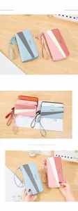 Detail of color-block long wallets with zipper, wristlet strap, and tassel decoration
