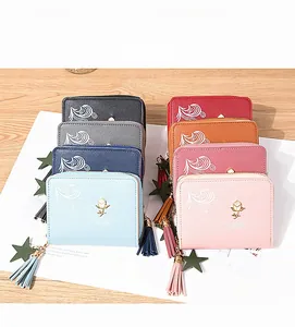 Close-up of colorful mini wallets with rose gold floral logo and tassel details