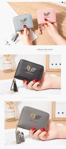 Detail of compact women's wallets with leaf pattern, metal zippers and cute rabbit charms