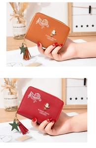 Close-up of elegant small wallets in brown and burgundy with star tassel zippers