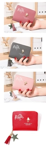 Detail of short leather wallets with rose metal buckle, tassel charms, and zipper closure