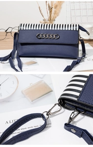 Detail of dark blue leather phone bag with black and white stripes and metal chain link