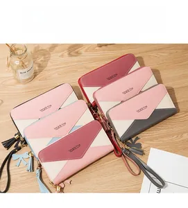 Close-up of long zip-around wallets with tassels and wristlets on a wooden desk