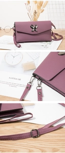 Macro detail of gunmetal butterfly hardware and adjustable strap on purple leather bag