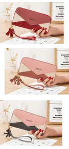 Detailed view of color-block long wallets with V-shaped patchwork and tassel zipper charms