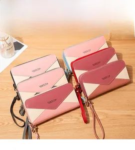 Stacked long color-block wallets with double zippers and wristlet straps on wood