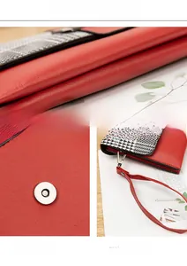 Detail view of red plaid long wallet showing lychee texture, magnetic buckle and wrist strap