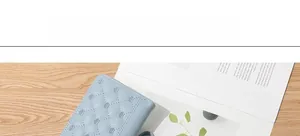 Detail of light blue quilted PU leather wallet with elegant silver crown accents