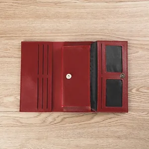 Detalle de cartera roja de piel sintética con ranura para móvil y múltiples tarjeteros