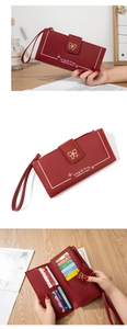 Detalle de cartera larga burdeos con textura de lichi y múltiples ranuras para tarjetas