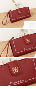 Detalle de cartera larga roja con hebilla de mariposa dorada y textura de piel fina