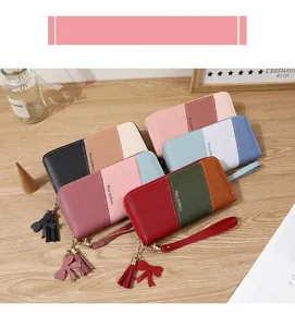 Detail of color-block long wallets with zip closure, bow tassel, and wristlet straps