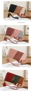 Detailed view of long zip-around wallets with tassel and heart charm in four colorways