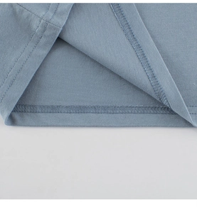 Detailed close-up of gray-blue cotton t-shirt hem with professional double-needle stitching