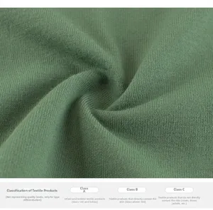 Macro detail of bean green ribbed knit fabric and textile safety standards label