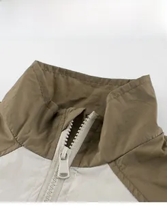 Detail view of the high-quality zipper and color-block collar on the kids' woven jacket