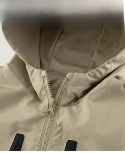 Detail showing the resin zipper closure and hood stitching on this beige kids hooded jacket