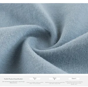 Detail of light blue knit cotton fabric showing safety standards A, B, and C classifications