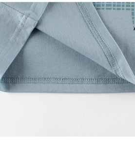 Detail view of double-needle stitching and smooth knit fabric on blue toddler t-shirt