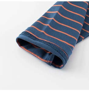 Détail d'un t-shirt enfant à manches longues montrant des poignets rayés bleu et orange