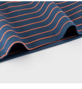 Détail du tissu en maille rayé bleu marine et orange avec finition à double couture