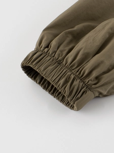 Olive green boys woven jacket featuring elastic ribbed cuffs and premium stitching