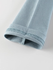 Close-up of light blue knit cuff detail on kids long sleeve t-shirt with lockstitch edge