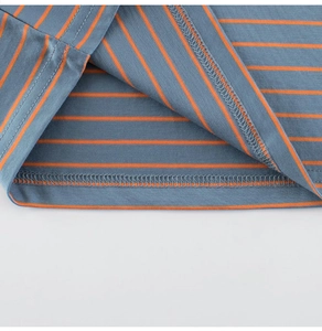 Détail de l'ourlet du t-shirt rayé bleu et orange avec coutures à double aiguille