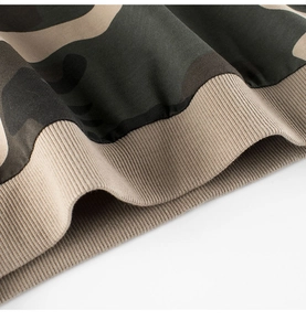 Macro detail of camouflage print and ribbed knit hem on boys' sweatshirt fabric