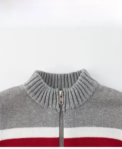 Close-up of ribbed stand collar and metal zipper on grey, white, and red striped kids sweater