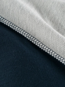 Detail of premium overlock stitching on navy and grey knit fabric for kids' clothing set
