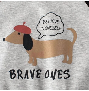 Close-up of grey sweatshirt fabric with a cartoon dachshund and 'Believe in Oneself' text