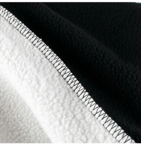 Close-up of boys sweatshirt fabric with black plush and white sherpa lining texture