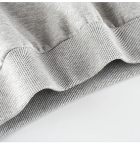 Close-up of gray heather knitted sweatshirt featuring elastic ribbed hem detail