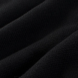Macro shot of high-quality black knitted fabric showing fine texture and soft yarn detail