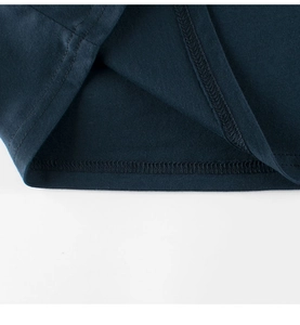 Close-up of double-needle stitching on the hem of a navy cotton boys' T-shirt