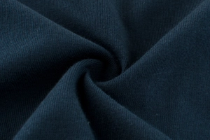 Close-up of navy blue knitted cotton fabric showing soft texture and fine grain detail