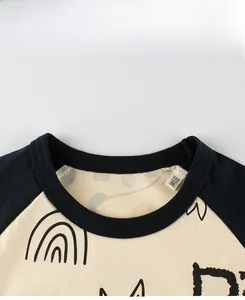 Dettaglio dello scollo della maglietta con maniche raglan ed etichetta della taglia