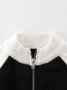 Kids black and white knit sweater featuring a white ribbed collar and metal zipper