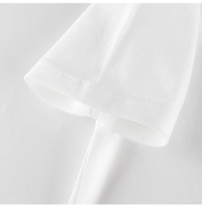 Vue macro des coutures à double aiguille sur le poignet d'un t-shirt en coton blanc