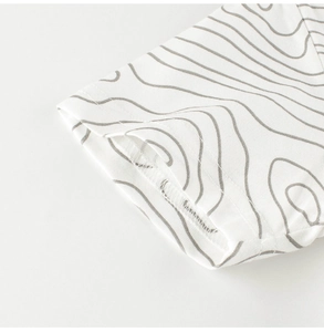 Detail of soft cotton sleeve cuff with grey wave pattern and neat stitched hem